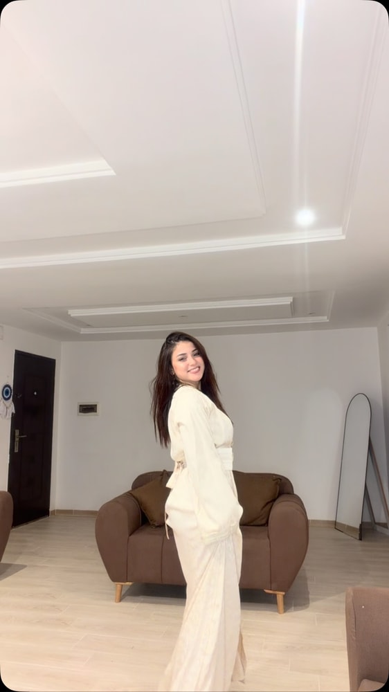 عارضة ترتدي قفطاناً كريمياً طويلاً